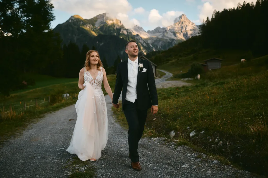Brautpaar im Abendlicht auf alpiner Wiese